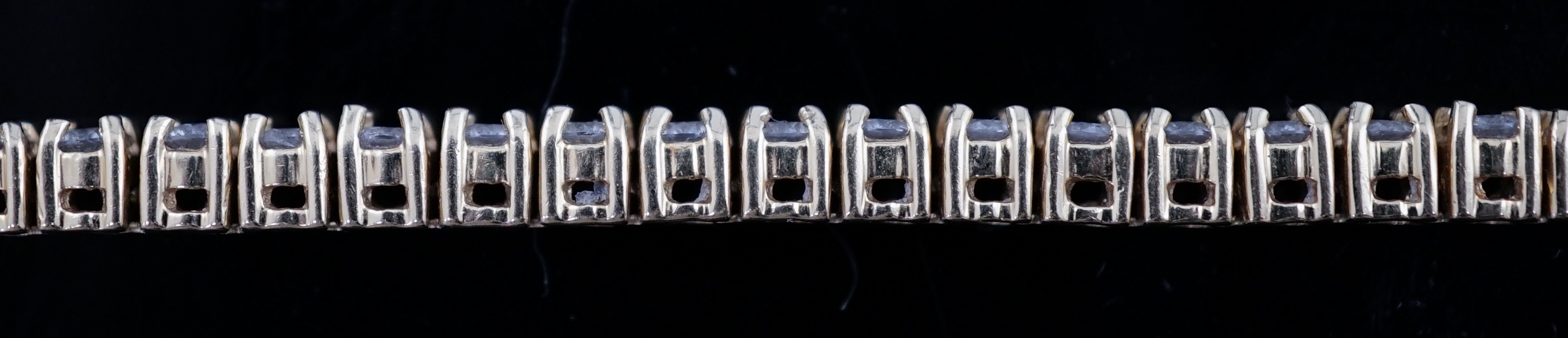 A modern 18ct gold and fifty nine stone round brilliant cut diamond set line bracelet